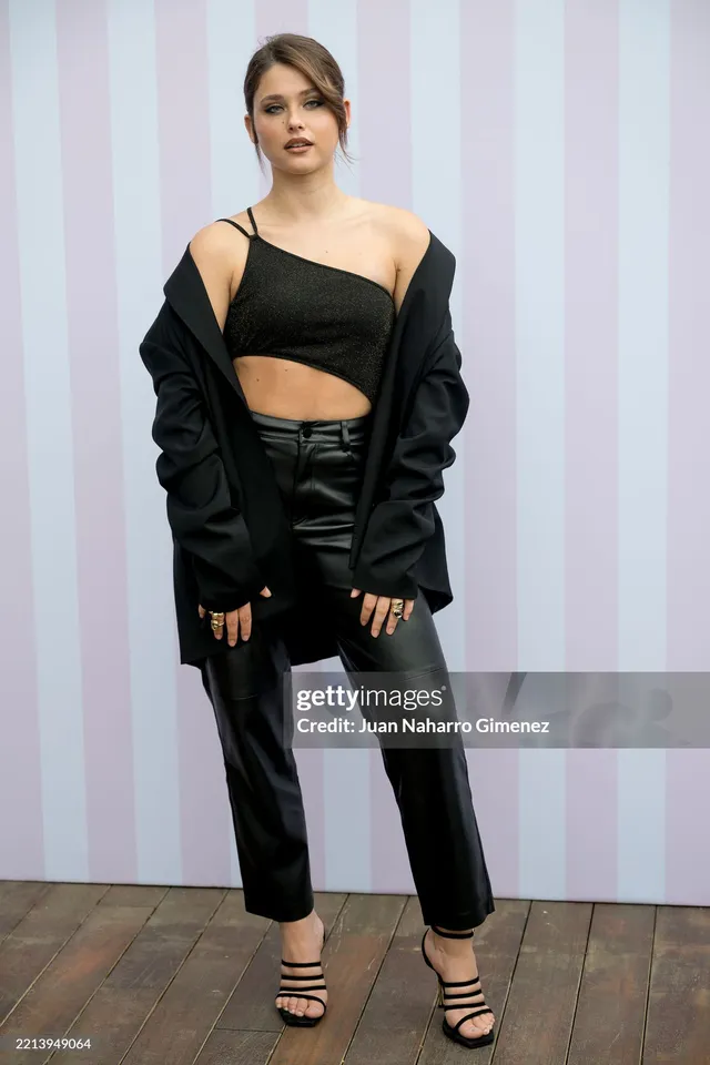 Nicole Wallace wearing an asymmetric black outfit and black heels at an event.