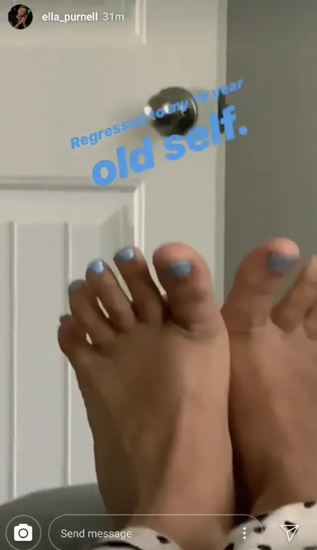 Ella Purnell resting her feet with pale blue nail polish.
