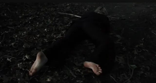 Victoria Pedretti reclining on the ground during a screen scene.