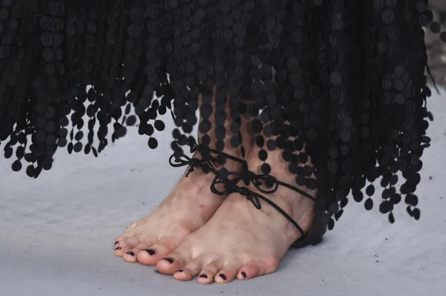 Margaret Qualley a close detail of black lace up sandals.