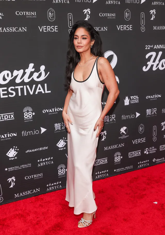 Vanessa Hudgens wearing a white dress and metallic heels.