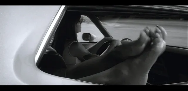 Rosario Dawson resting her feet outside a car window.