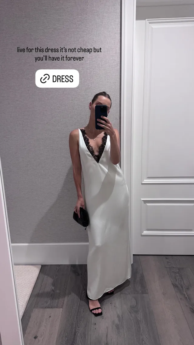 Claire Holt taking a mirror portrait in a pale dress.