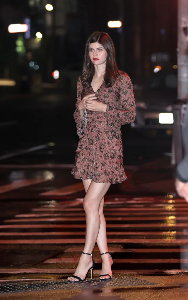 Alexandra Daddario wearing a patterned mini dress and black heels.