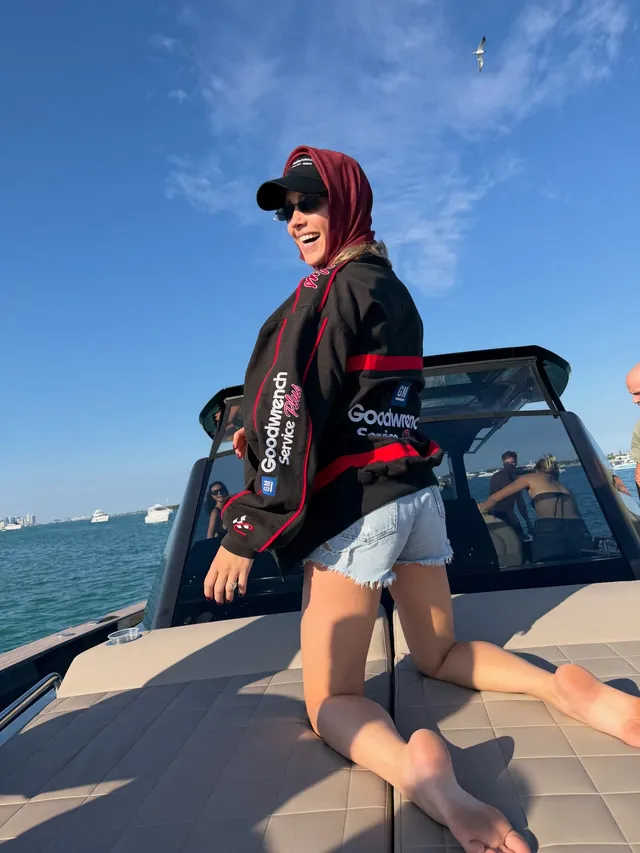Claire Holt kneeling on the deck of a boat.