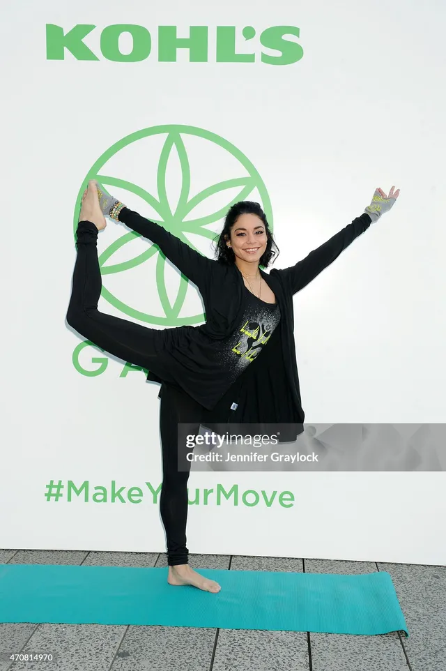 Vanessa Hudgens standing barefoot in a yoga pose with one leg raised.