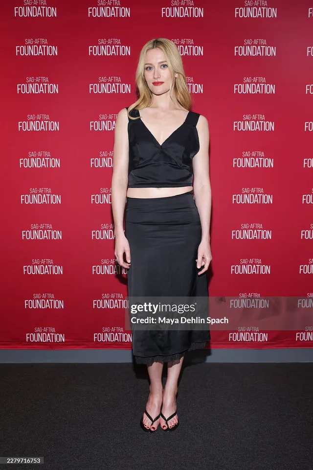 Sarah Pidgeon wearing a black cropped top, skirt and flat sandals at an event.