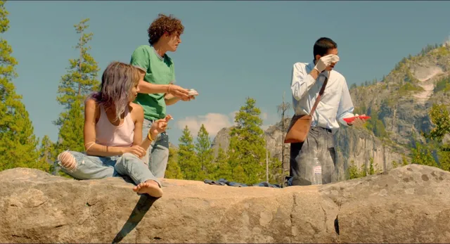 Zoë Kravitz sitting outdoors in a rocky screen setting.