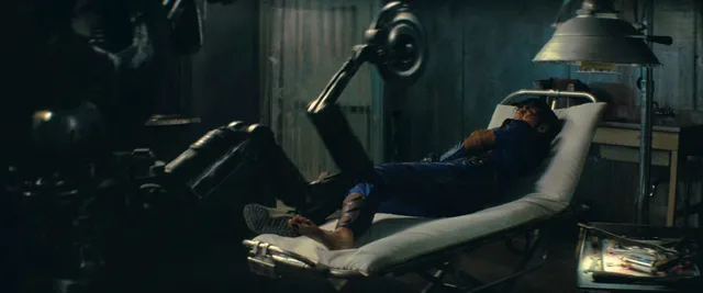 Ella Purnell reclining in a chair in a dramatic screen scene.