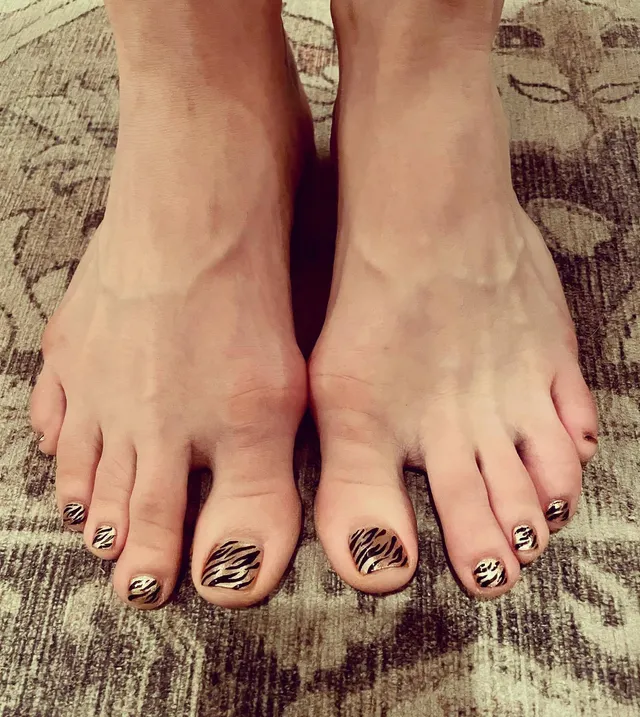 Chloë Grace Moretz showing patterned toenail polish in close view.