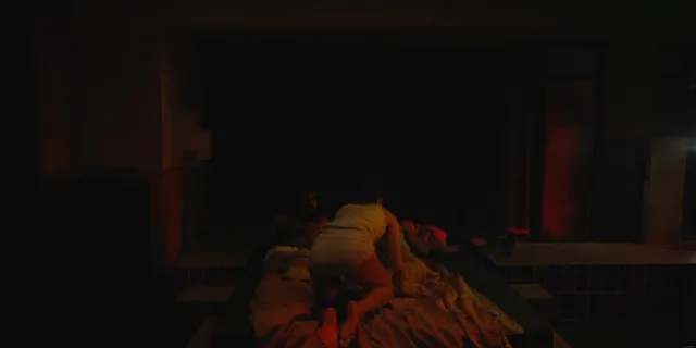 Alicia Vikander reclining in a dimly lit screen scene.