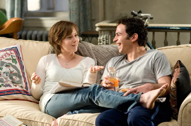 Amy Adams sitting beside a companion during a screen scene.