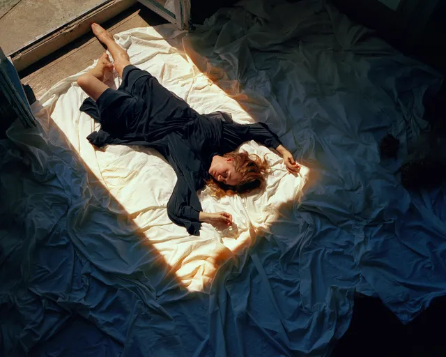 Amy Adams reclining on a bed during a screen scene.