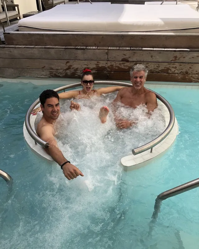 Hailee Steinfeld sitting with friends in a poolside hot tub.