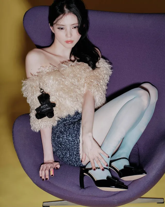 Han So-hee sitting in tights and black heels.