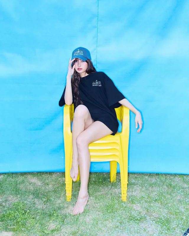 Lisa (Lalisa Manobal) sitting in a yellow chair wearing a dark T-shirt during a studio portrait.