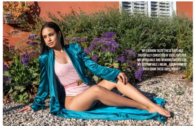 Emily Tosta reclining barefoot outdoors in a blue robe.