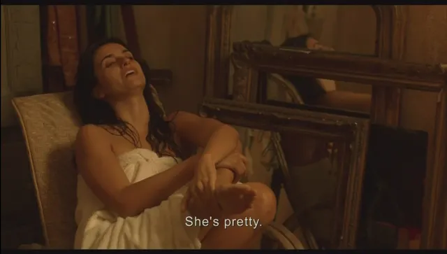 Penélope Cruz reclining in a chair with a bare foot visible in a film scene.