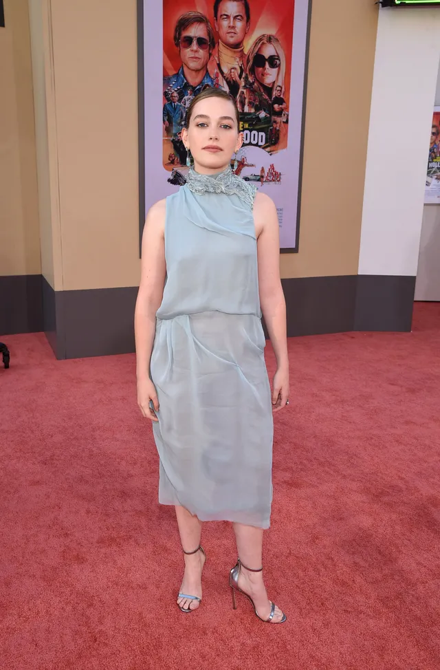 Victoria Pedretti posing at a premiere in a pale blue dress.