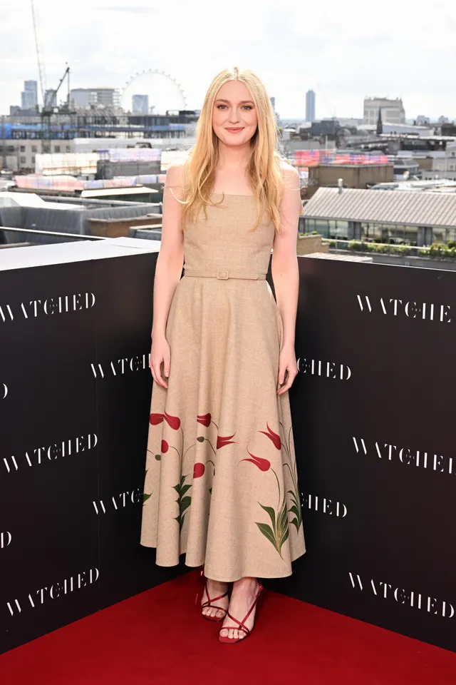 Dakota Fanning wearing a pale dress and black heels at a film event.
