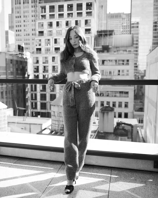 Havana Rose Liu posing on a balcony in metallic heels.
