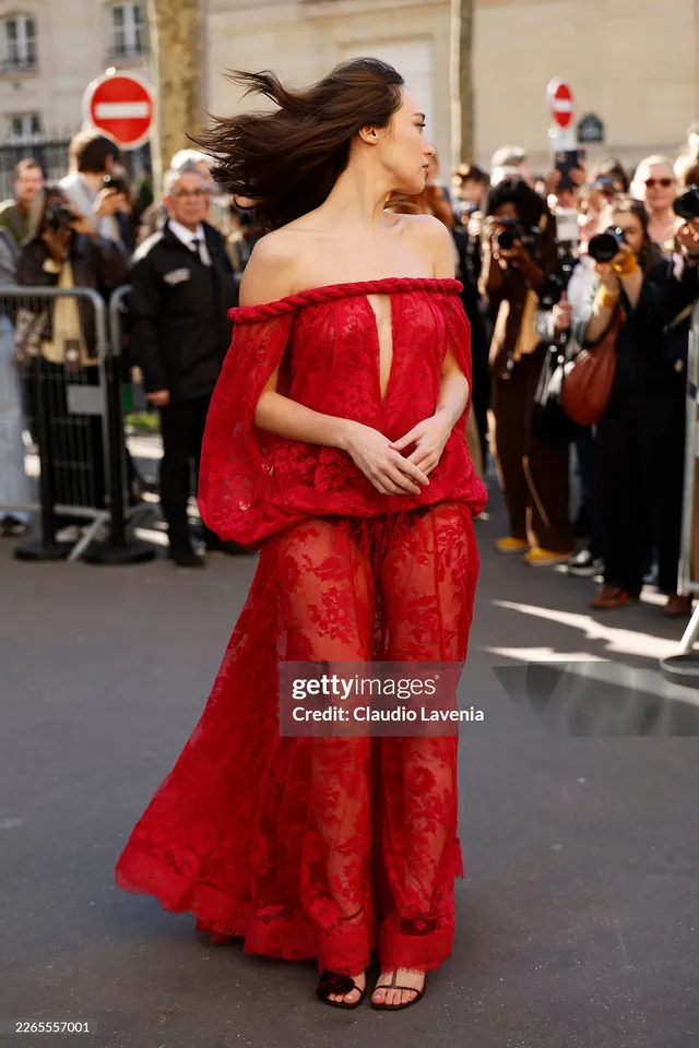 Alycia Debnam-Carey posing outside a venue in a long red dress.
