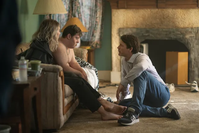 Vanessa Kirby a seated screen scene beside other characters.