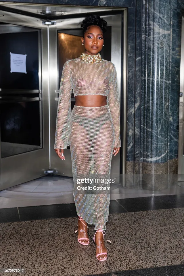 Carlacia Grant walking outside in a silver skirt set and pink heels.