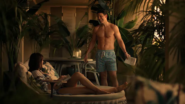 Alexandra Daddario sitting barefoot on a patio in a television scene.