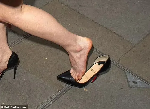Anya Taylor-Joy wearing black pointed heels on a pavement.