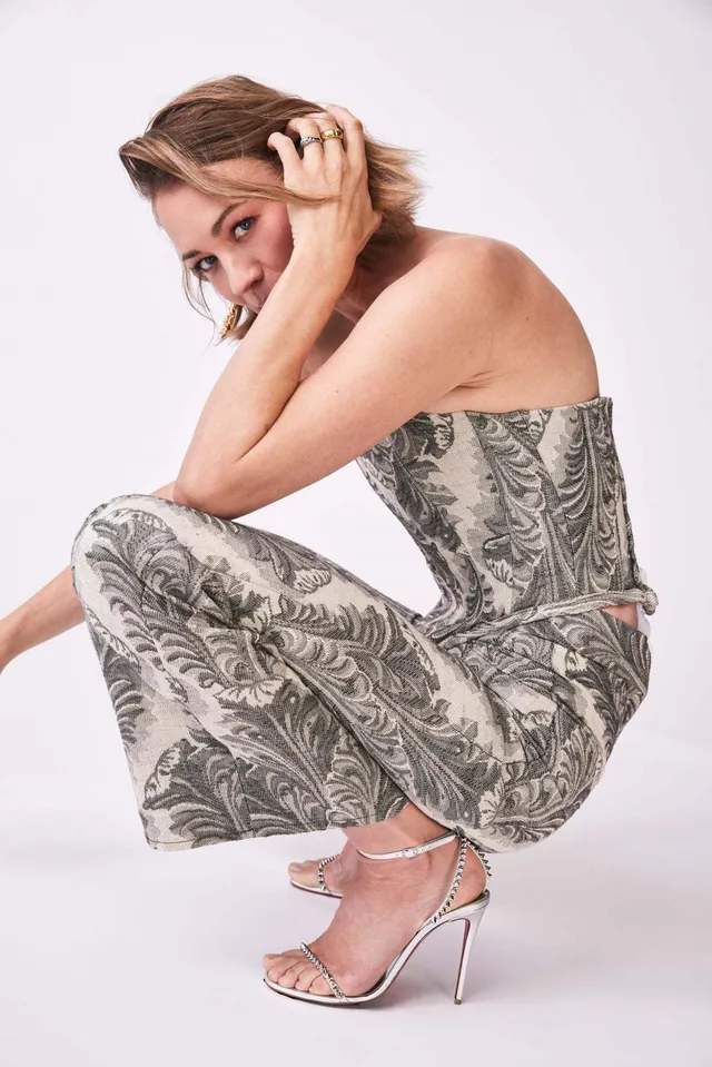 Yvonne Strahovski crouching for a portrait in a patterned outfit.