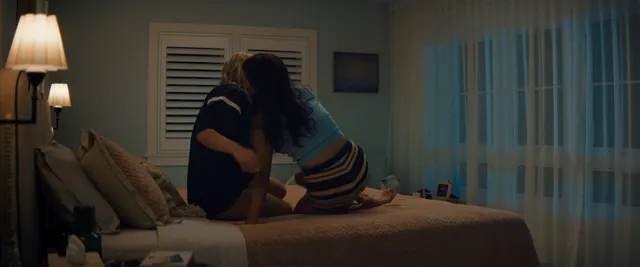 Chase Sui Wonders sitting on a bed with a companion in a scene.