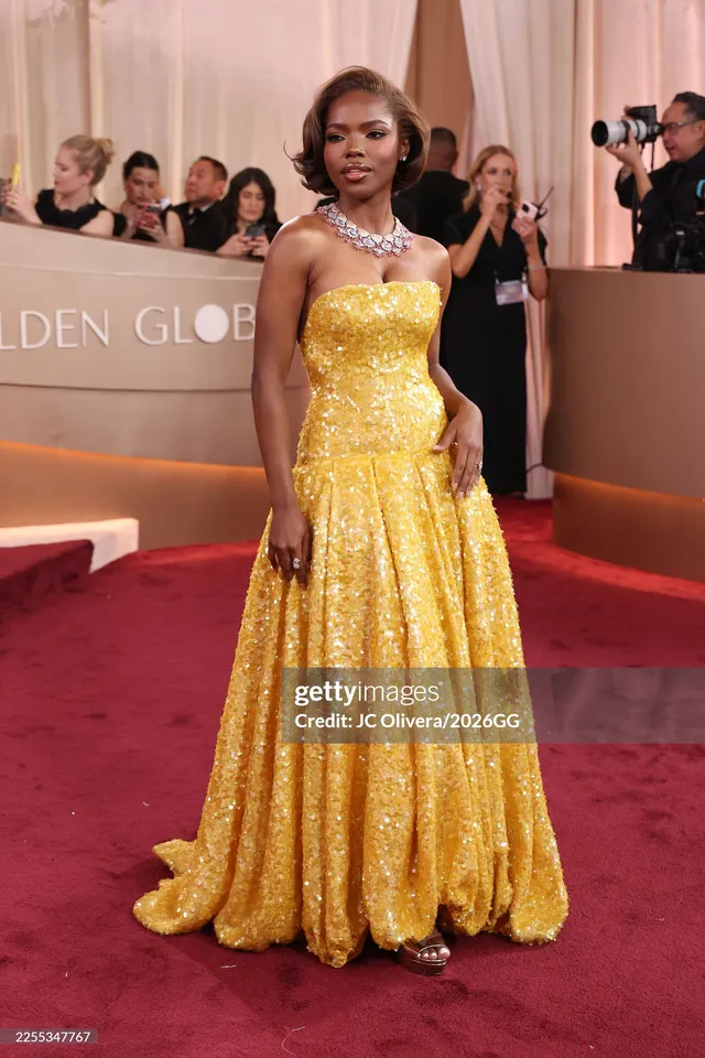 Ryan Destiny wearing a long gold gown on a red carpet.