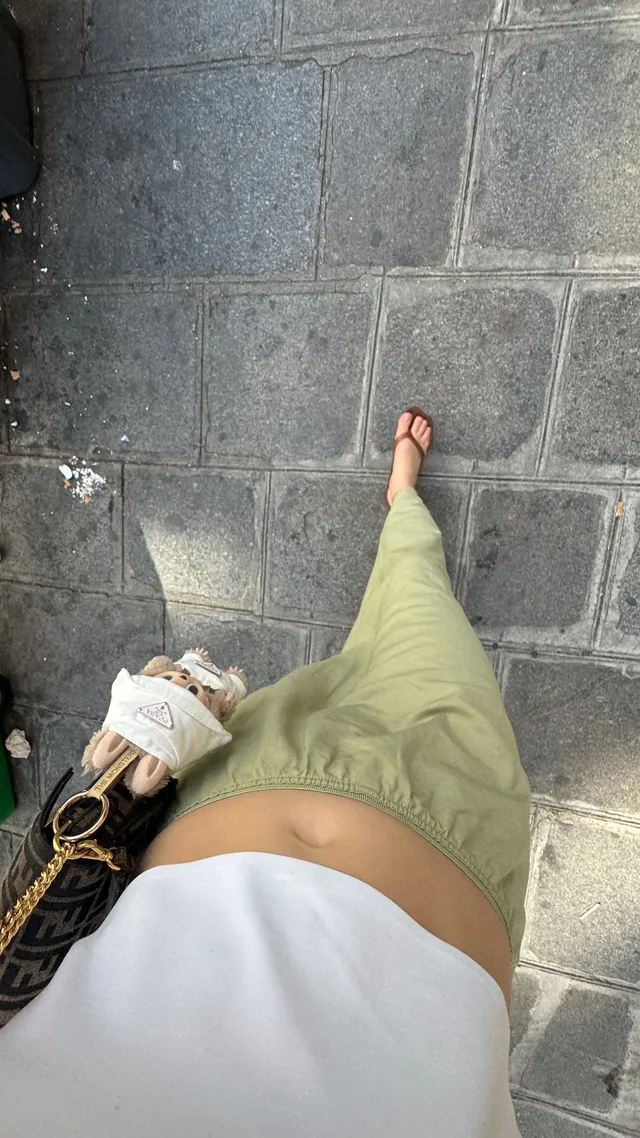 Adelaide Kane a casual outfit portrait in green trousers and sandals.