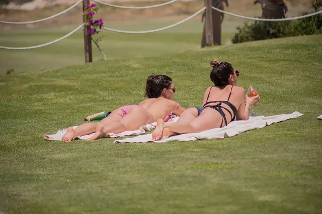 Danielle Campbell relaxing with a companion on a grassy bank.