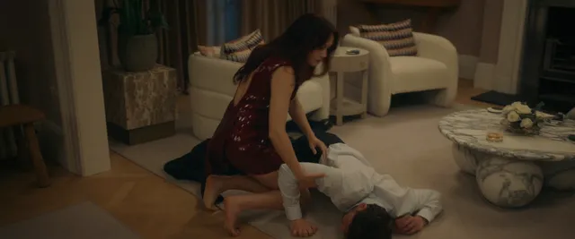 Olivia Cooke kneeling beside furniture in a dramatic scene.