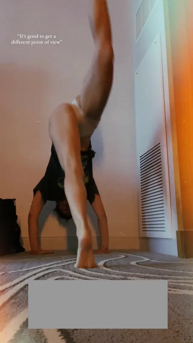 María Gabriela de Faría lowering her bare feet from a handstand.