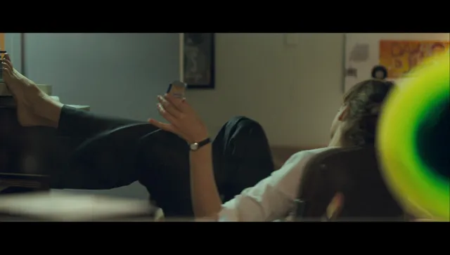 Rachel McAdams with bare feet extended beside another person indoors.