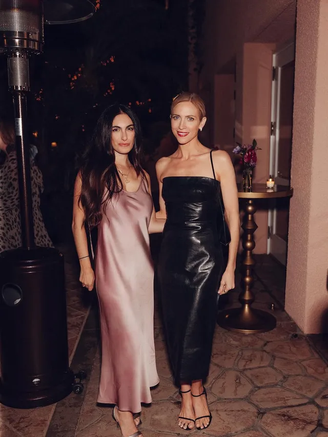 Brittany Snow posing with a companion in a black evening dress.
