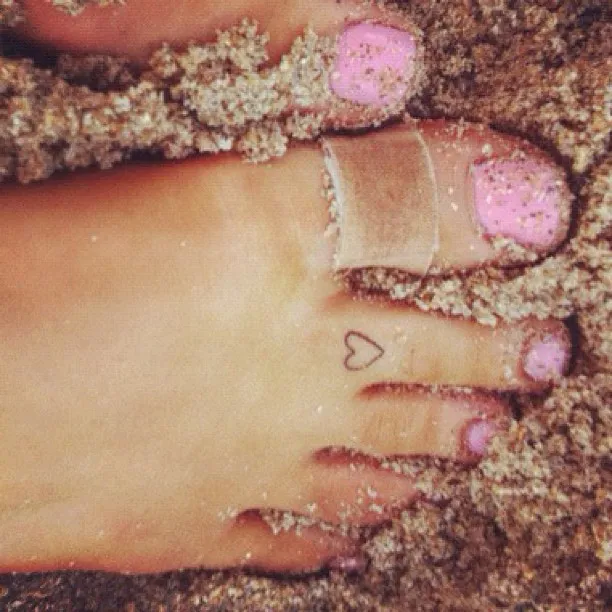 Ariana Grande showing painted toenails in a close-up.