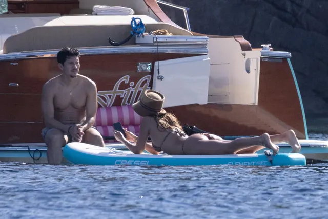 Jessica Alba relaxing barefoot on a floating platform.