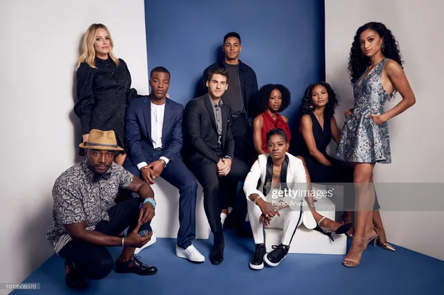 Samantha Logan posing with fellow performers in a patterned dress and heels.