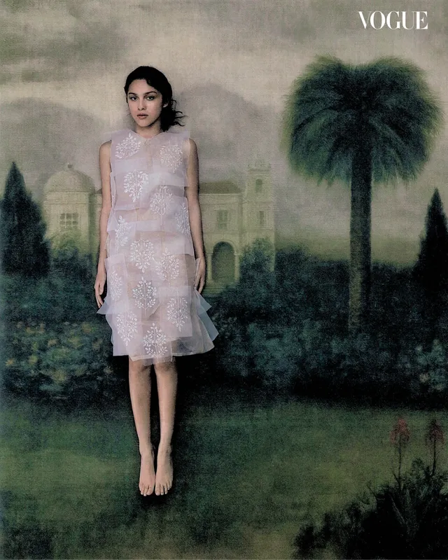 Olivia Rodrigo standing in a pale dress for a magazine portrait.