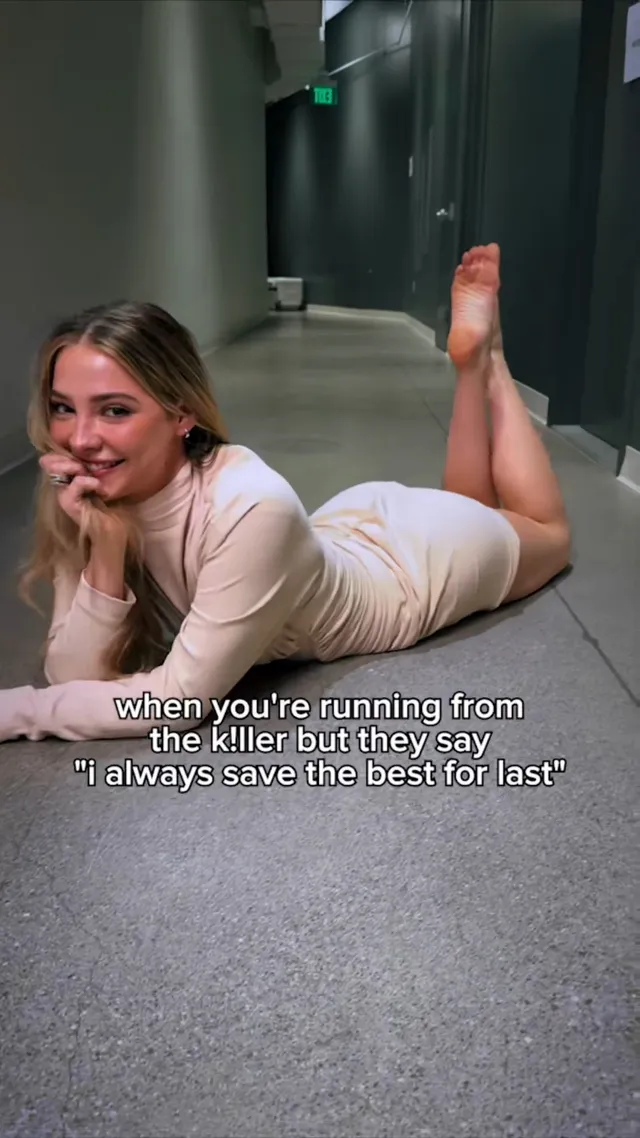 Madelyn Cline lying on a corridor floor with her bare feet raised.