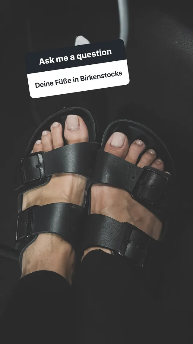 Heidi Klum wearing black buckled flat sandals.