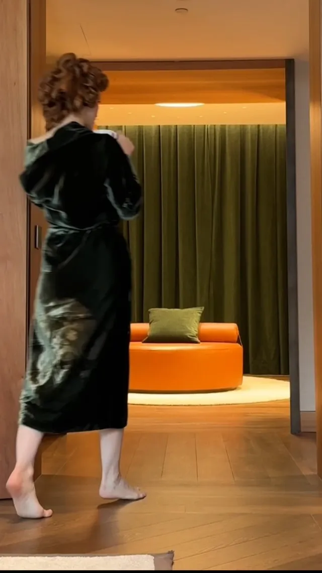 Jessica Chastain standing with her back turned in a dark robe.