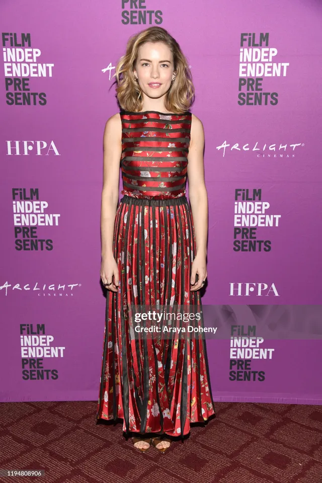 Willa Fitzgerald wearing a red patterned gown and heels at an event.