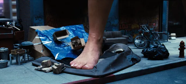 Sydney Sweeney showing a bare foot on a cluttered table in a film scene.
