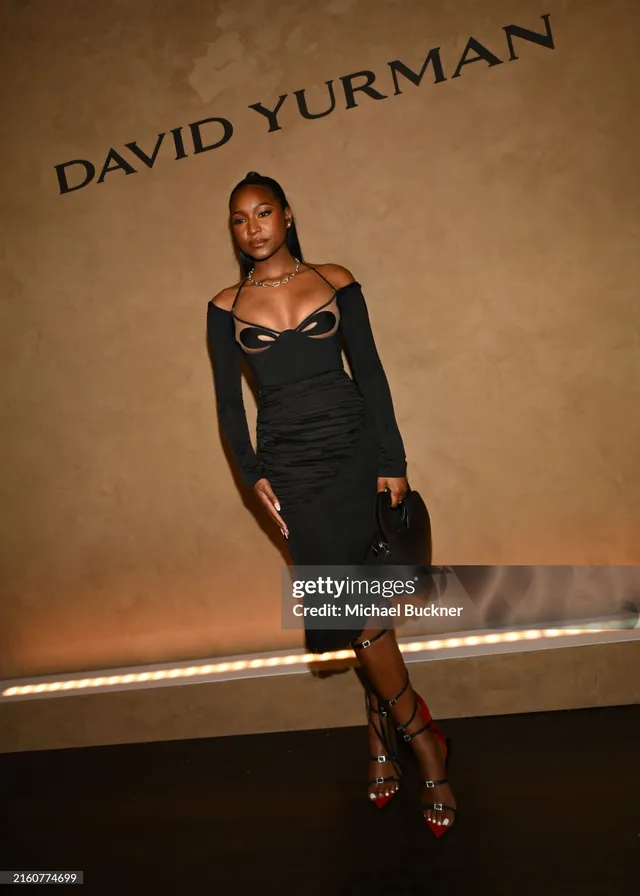 Carlacia Grant wearing a black dress and colorful strappy heels at an event.