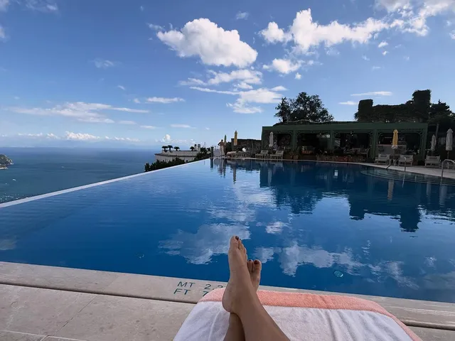 Vanessa Hudgens resting bare feet beside an infinity pool.